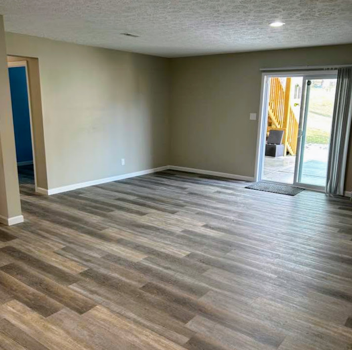 Empty living room with newly installed vinyl plank flooring and neutral wall colors